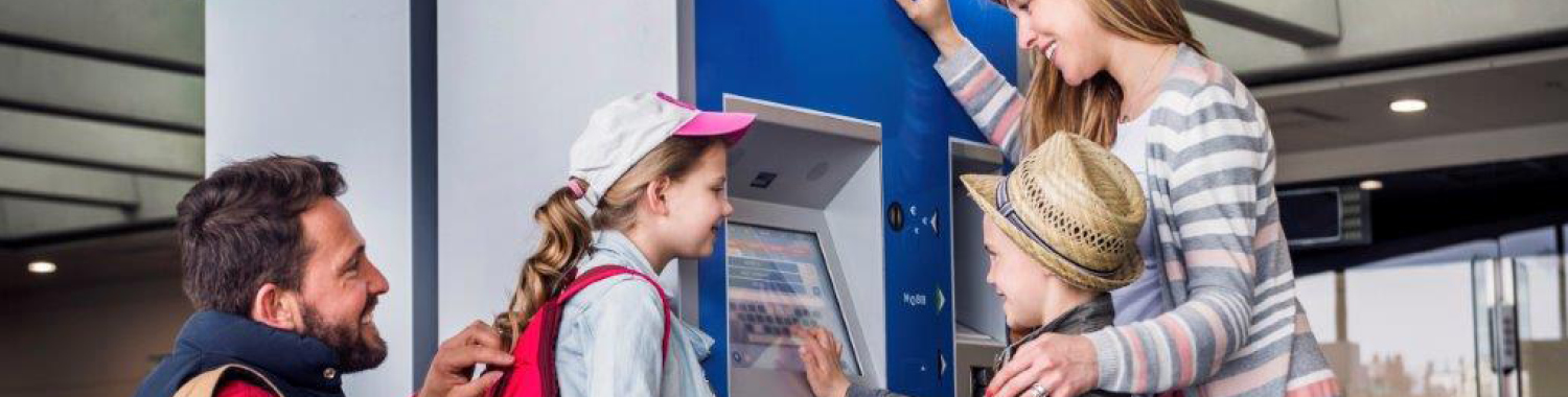 Famille avec enfants achetant un ticket à l'automate