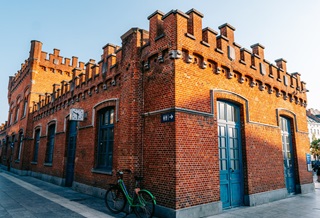 Bicyclette contre la façade de la gare d'Alost