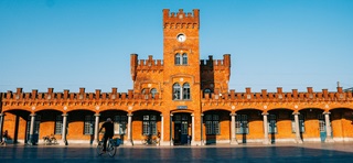 Façade de la gare d'Alost avec tour et galerie juste avant le coucher du soleil