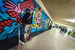 Graffiti-artiest met step voor street art in tunnel station Antwerpen-Berchem