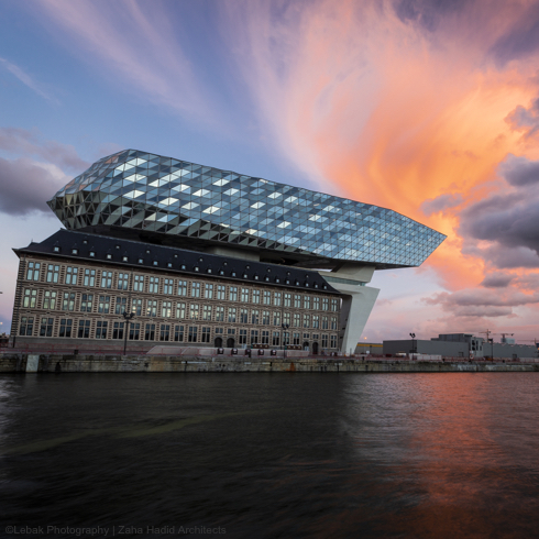 Zicht Havenhuis Antwerpen vanaf de Schelde met zonsondergang