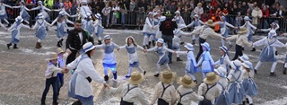 par dizaine des enfants habillés à l'ancienne danse en ronde au milieu du cortège de carnaval