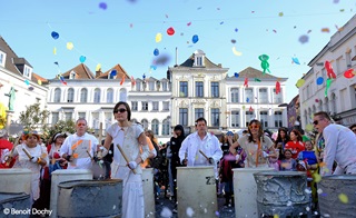 une foule sur la grand place de Tournai avec des confettis plein le ciel