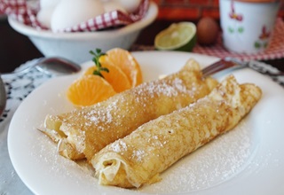 Deux crèpes roulées avec des morceaux de mandarines
