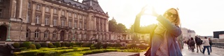 Une dame les mains en coeur devant le Palais Royal de Bruxelles
