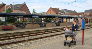 Une femme avec une pousette sur le quai de la gare