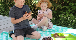 Deux enfants pique-niquent sur une couverture