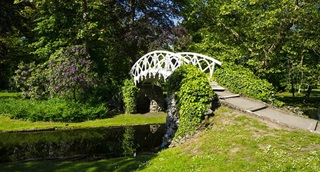 Un pont en métal forgé blanc traverse le parc.