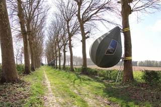 Une tente gonflable est attachée aux arbres.