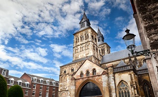 Onze-Lieve-Vrouwebasiliek in Maastricht tegen een stralend blauwe hemel