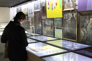 Een bezoekster bewondert de kunstwerken in de Artotheek van Bergen